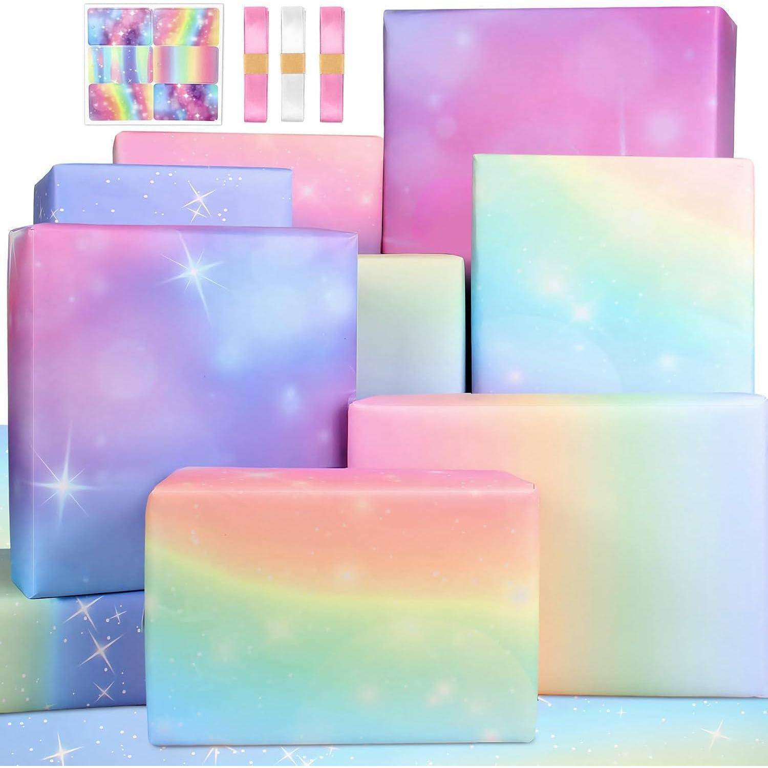 Bunte Geschenkkartons und Bänder in pastellfarbenen Regenbogentönen mit Sternenmustern in einer gestapelten Anordnung.