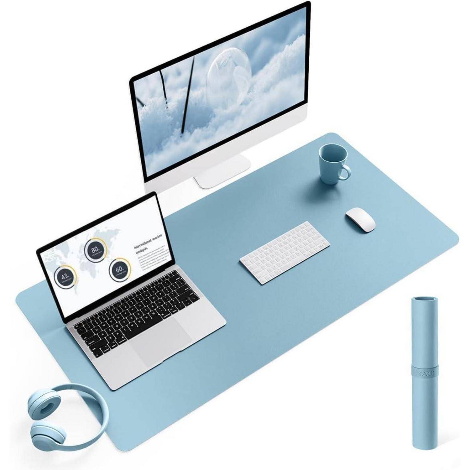 Ein aufgeräumter Arbeitsplatz mit einem Desktop-Monitor, einem Laptop mit Diagrammen, Tastatur, Maus, Kopfhörern, einer Tasse und einer hellblauen Schreibunterlage.