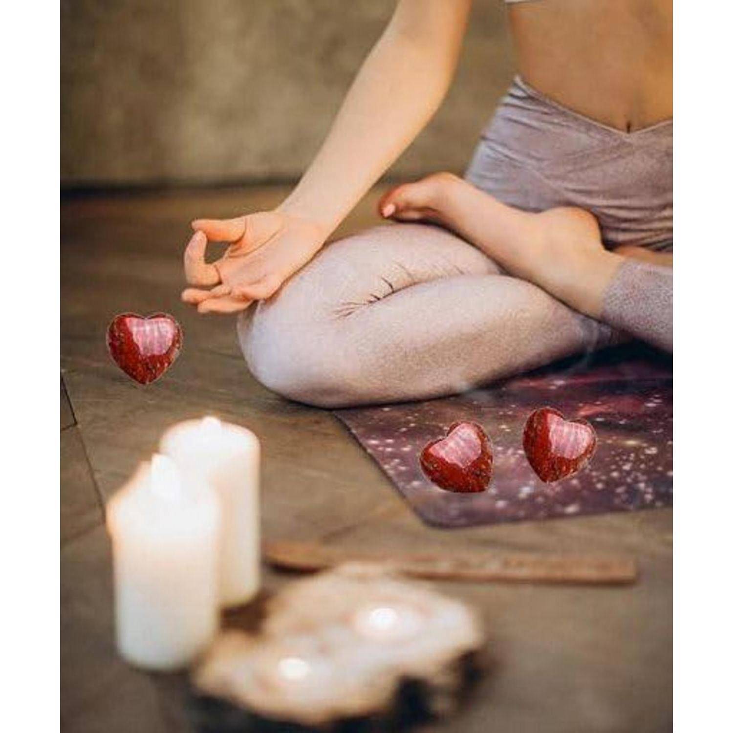 Eine Person sitzt im Schneidersitz in einer meditativen Haltung, umgeben von Kerzen. Drei schwebende Herzformen verleihen eine beruhigende und friedvolle Atmosphäre.