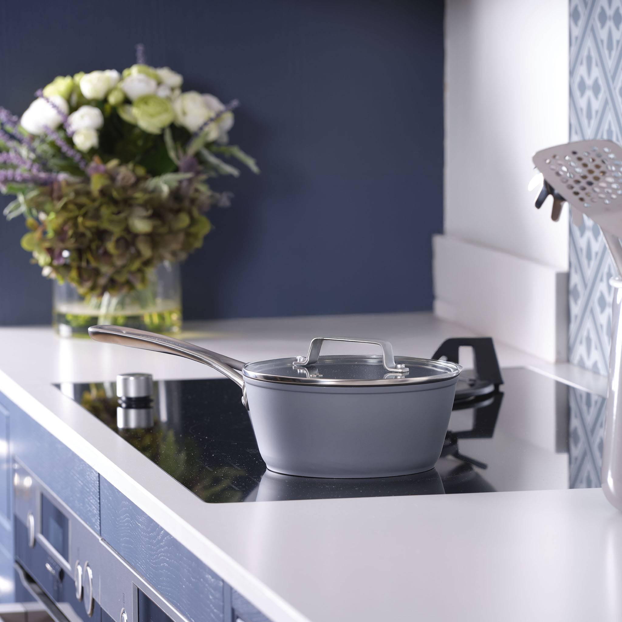 Ein großer grauer Kochtopf mit Griffen und Glasdeckel, geeignet für die Verwendung auf dem Herd.