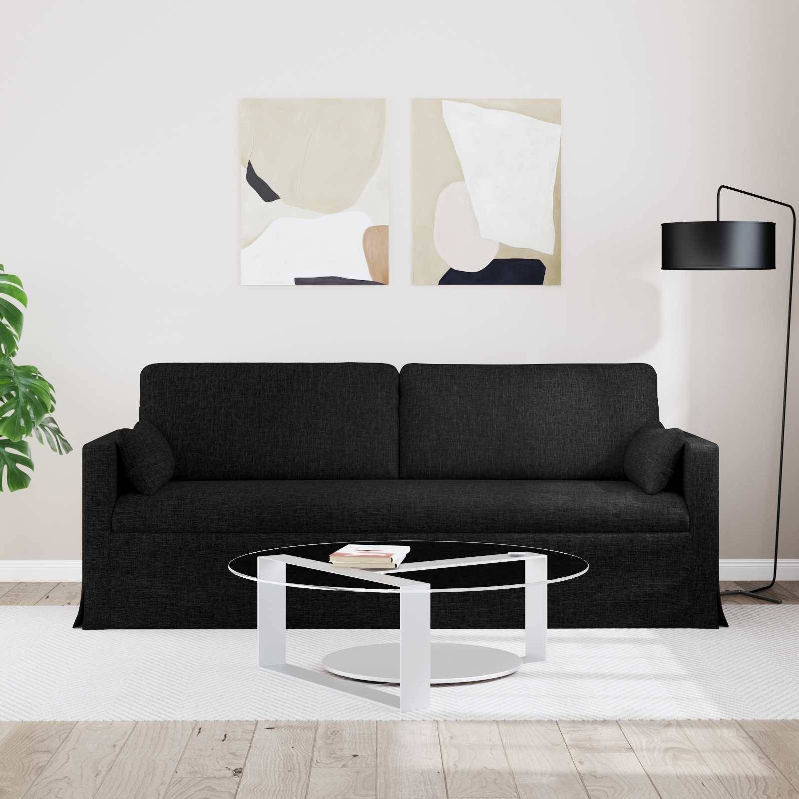 Ein modernes Wohnzimmer verfügt über ein schwarzes Sofa, einen Glascouchtisch mit einem Buch, abstrakte Kunst an der Wand und eine Stehlampe.