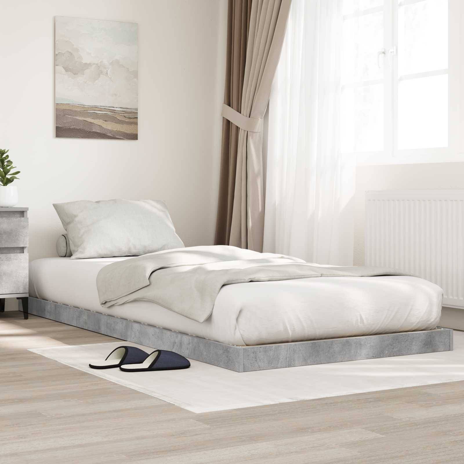 Ein minimalistisches Schlafzimmer mit einem flachen Bett, weißer Bettwäsche, einer grauen Decke, Kissen, einem Nachttisch, Hausschuhen, Kunstwerken und natürlichem Licht.