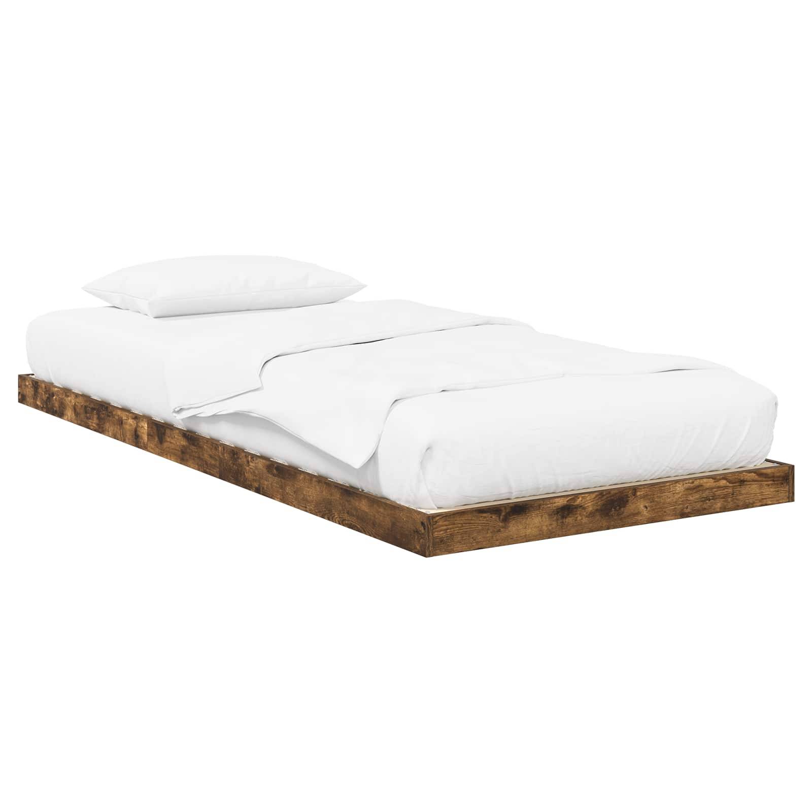 Ein Holz-Plattformbett mit einer weißen Matratze, einem weißen Laken und einem weißen Kissen.