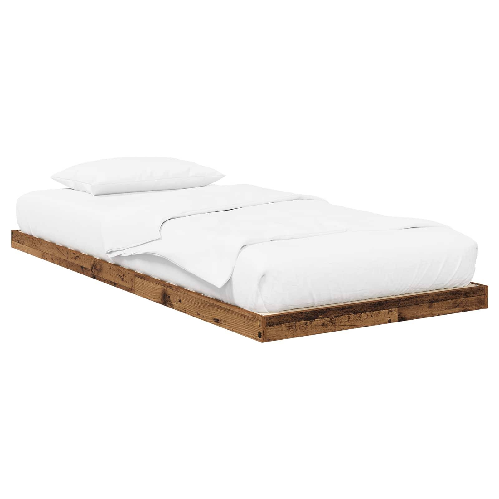 Ein minimalistisches Plattformbett mit rustikaler Holzbasis, bestückt mit einer weißen Matratze, einem weißen Laken und einem weißen Kissen, das einen sauberen, einfachen Look schafft.