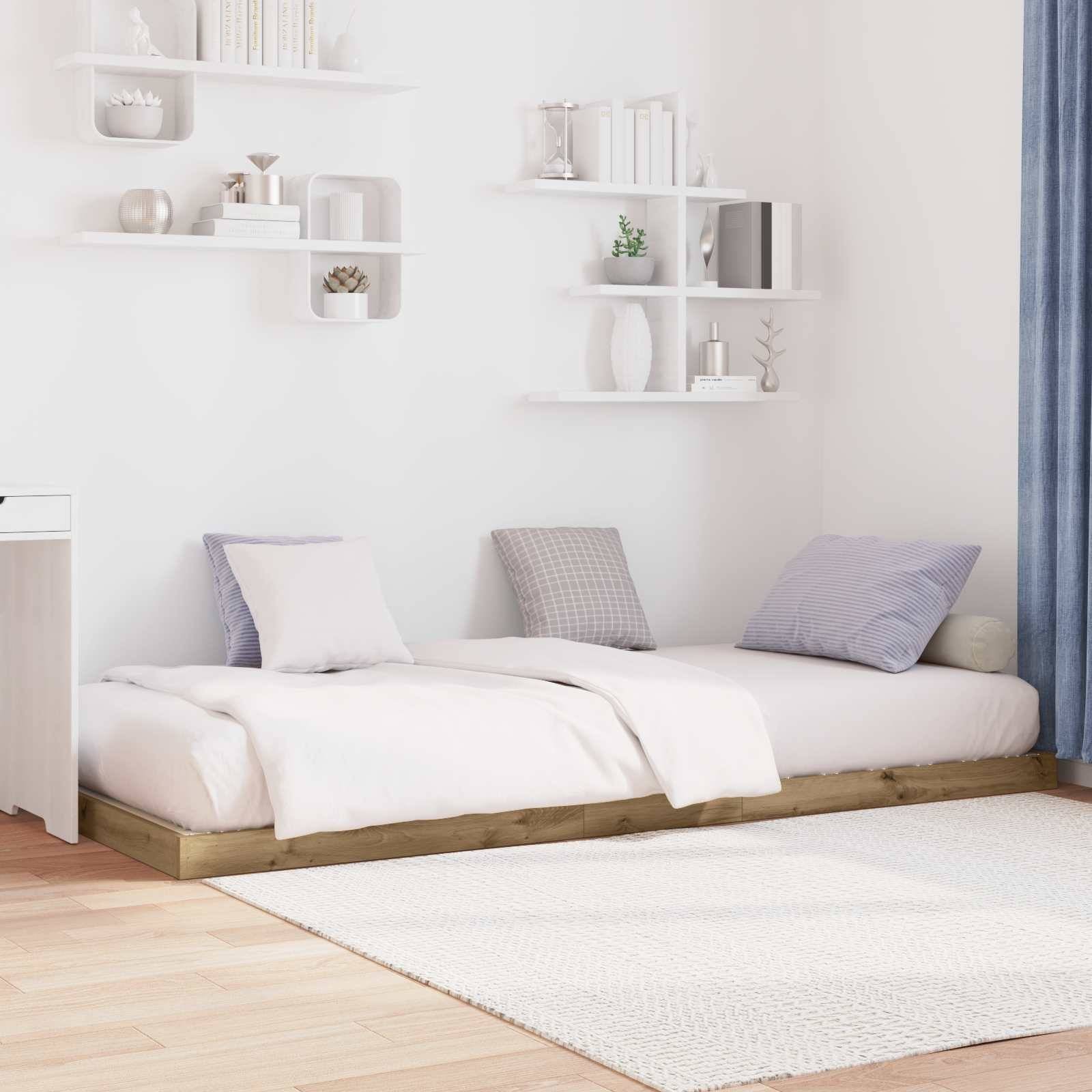 Ein minimalistisches Schlafzimmer mit einem flachen Plattformbett, weißen und grauen Kissen und schwebenden Regalen. Weiches Naturlicht filtert durch blaue Vorhänge.