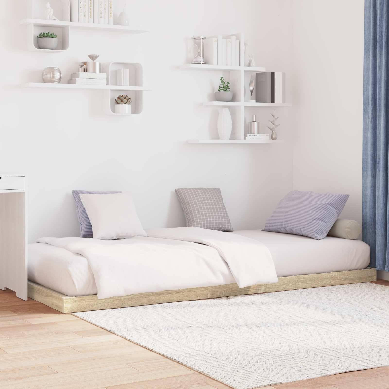 Ein minimalistisches Schlafzimmer mit einem niedrigen Bett, weißer Bettwäsche und pastellfarbenen Kissen. Weiße Regale halten Dekoration, und ein Vorhang ist teilweise zugezogen.