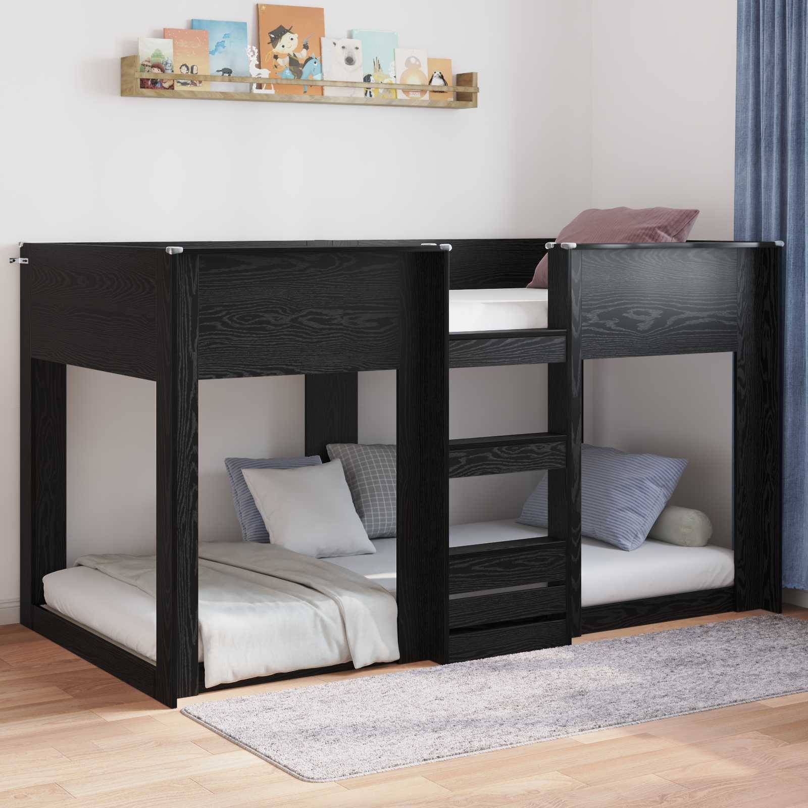 Ein Kinderzimmer mit einem schwarzen Hochbett aus Holz; das untere Bett ist offen, das obere Bett hat eine Schutzschiene, und dazwischen befindet sich eine Leiter. Ein Teppich liegt auf dem Boden, und Dekorationsgegenstände stehen auf einem Regal darüber.