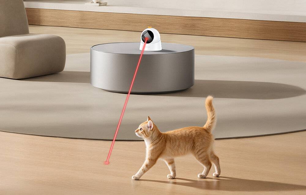 Ein grauer, kreisförmiger Luftauslass mit vertikalen Lamellen und einer zentralen Trennlinie, von vorne betrachtet, vor einem hellgrauen Hintergrund.