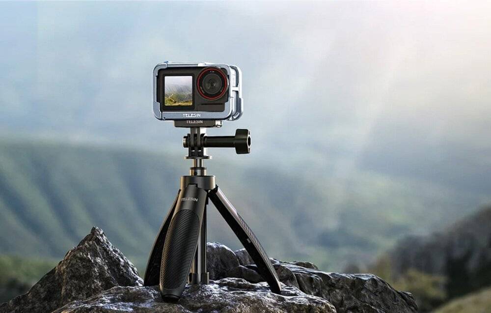 Eine kompakte Actionkamera auf einem Stativ montiert, vor einer unscharfen Berglandschaft positioniert, die Outdoor-Abenteuerfotografie suggeriert.