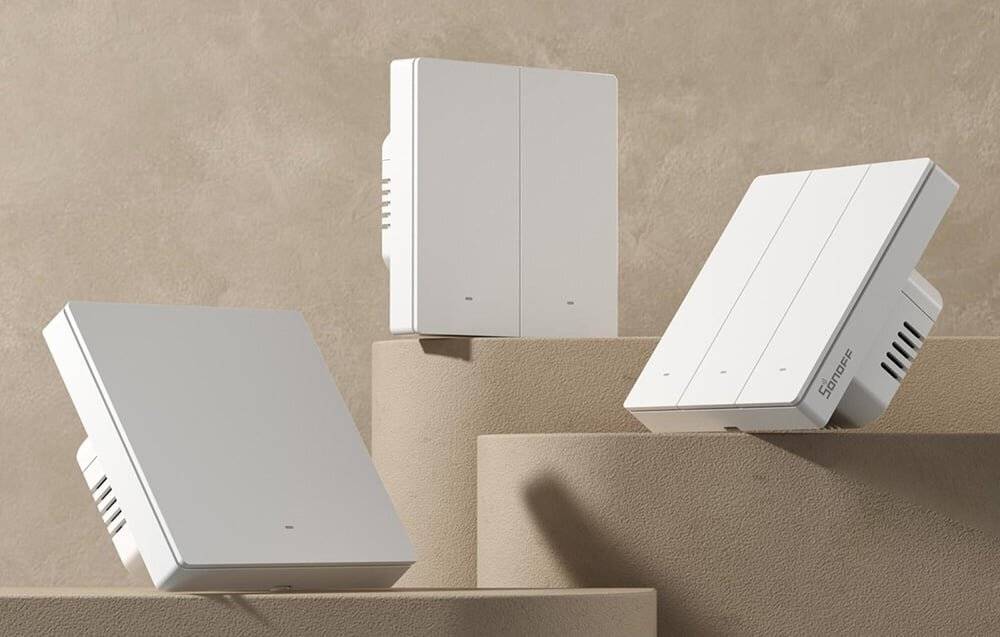 Moderne minimalistische Geräte mit schlankem Design sind auf gestuften beigen Plattformen vor neutralem Hintergrund ausgestellt und betonen Eleganz.