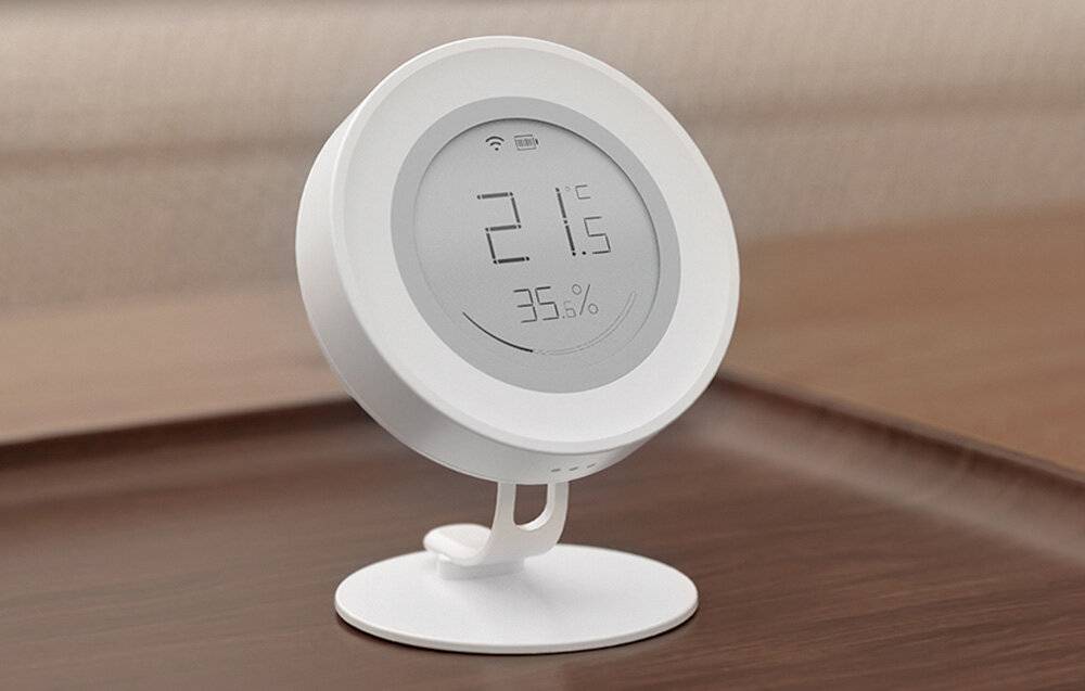 Ein digitales Thermometer auf einem Holztisch zeigt „21,6°C