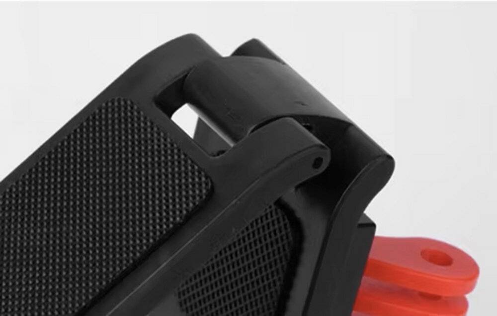 Eine kompakte Actionkamera mit einem Bildschirm, auf dem eine Person beim Surfen zu sehen ist. Sie befindet sich auf einer schwarzen, oval geformten Ladestation mit einer kreisförmigen Aussparung.