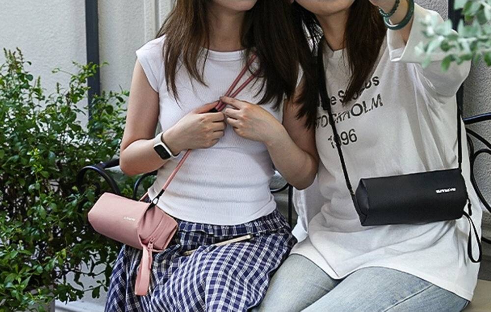 Action-Kamera in wasserdichtem Gehäuse, vor einem Bergpanorama positioniert. Das Display zeigt einen Snowboarder in der Luft.