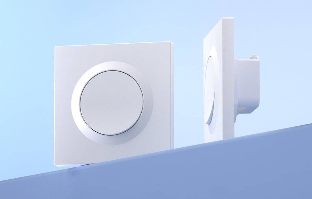 Ein weißer wandmontierter Bedienknopf in einer minimalistischen, modernen Inneneinrichtung, Schrägansicht mit zwei Knöpfen auf blauem Hintergrund.