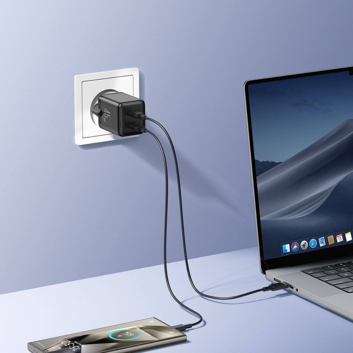 Ein Laptop mit einem blau-grauen Bildschirm sitzt auf einem Schreibtisch neben einem Smartphone und Kopfhörern. Ein Ladegerät ist in die Wandsteckdose eingesteckt.