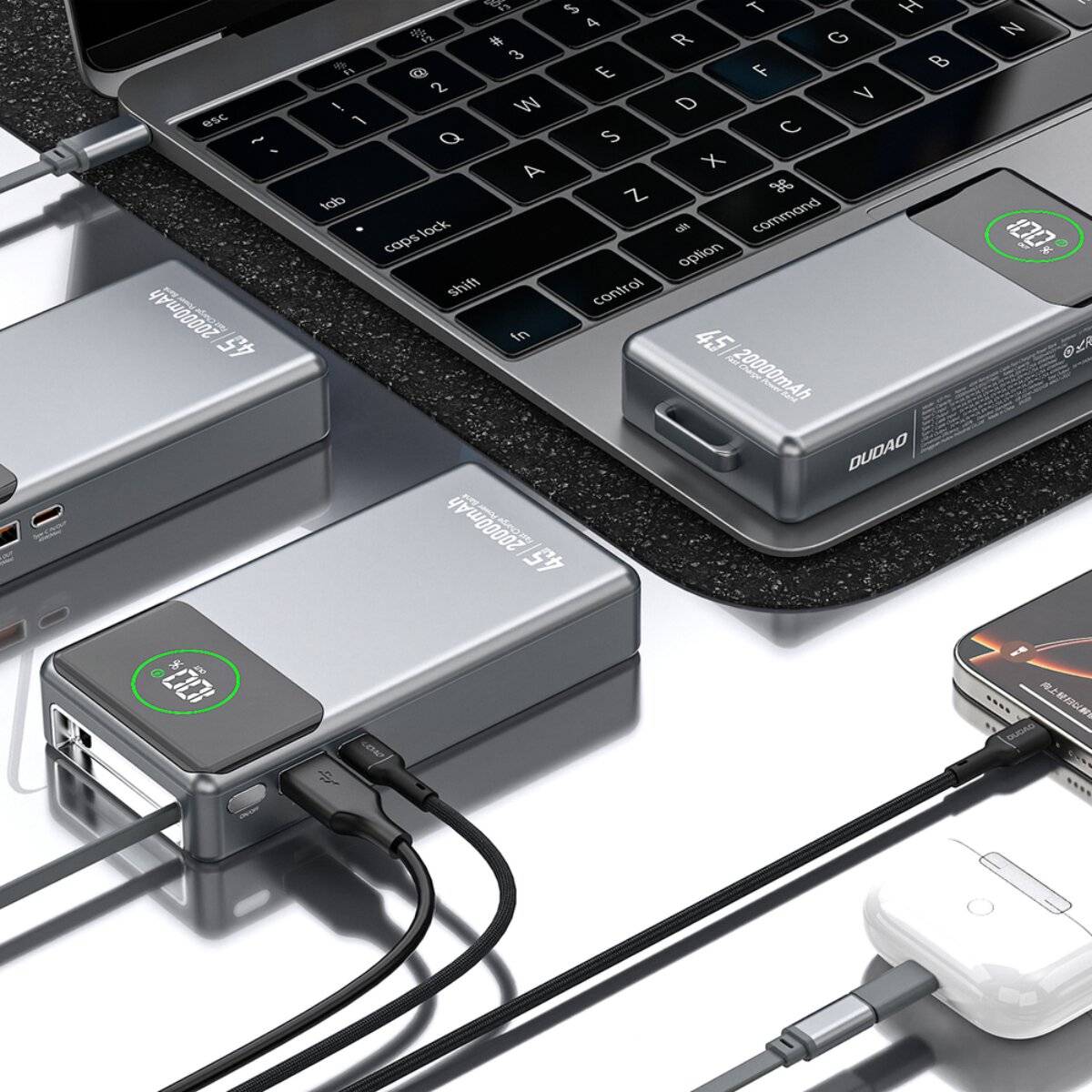 Tragbare Powerbanks laden verschiedene Geräte neben einem Laptop auf und zeigen ihre Verwendung zum Laden von elektronischen Geräten.