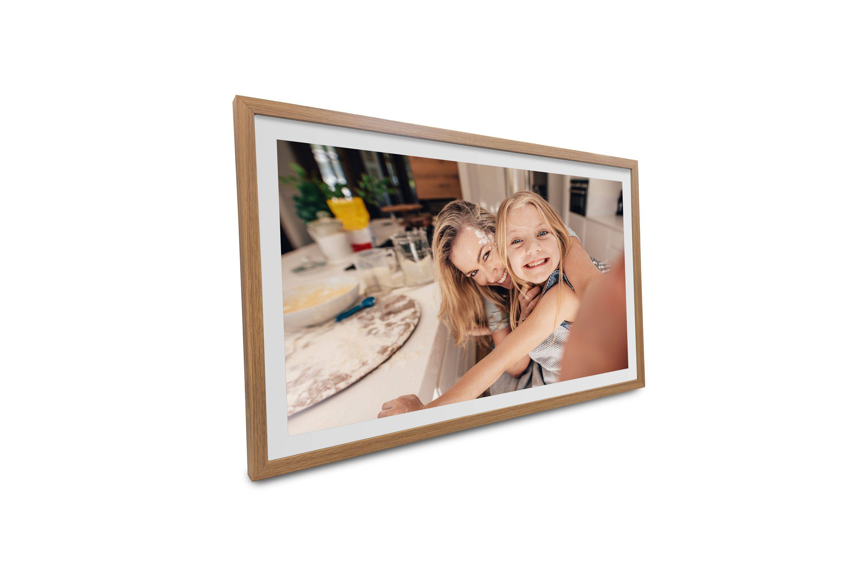 Ein gerahmtes Foto von zwei Personen, die in einer Küche lächeln, umgeben von Backzutaten, das einen freudigen Moment zeigt.