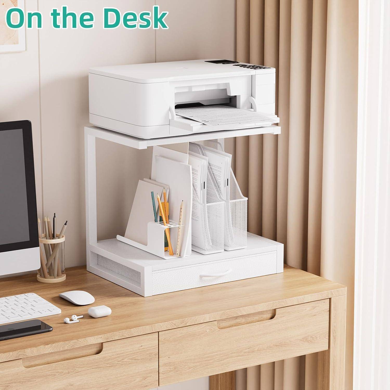 Ein ordentlich organisierter Arbeitstisch im Home-Office zeigt einen weißen Drucker auf einem Ständer, umgeben von Schreibwaren und Papierorganizern, neben einem Computermonitor.