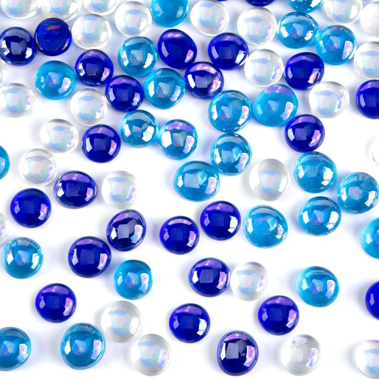 Blaue, weiße und violette Glaskiesel verstreut auf einer weißen Oberfläche, die ein farbenfroches Muster erzeugen.