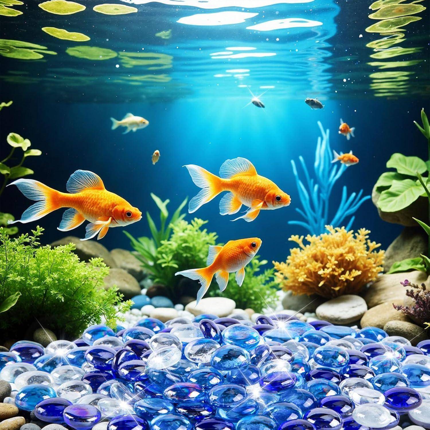 Drei lebendige Goldfische schwimmen in einem dekorativen Aquarium mit blauen Steinen und üppigen grünen Pflanzen, beleuchtet durch Sonnenlicht, das durch das Wasser strömt.