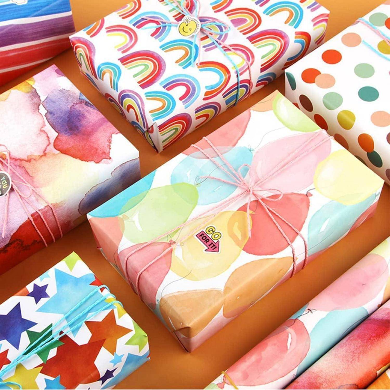 Bunte Geschenkboxen mit verschiedenen Mustern, einschließlich Regenbögen, Punkten und Sternen, angeordnet auf orangefarbenem Hintergrund.