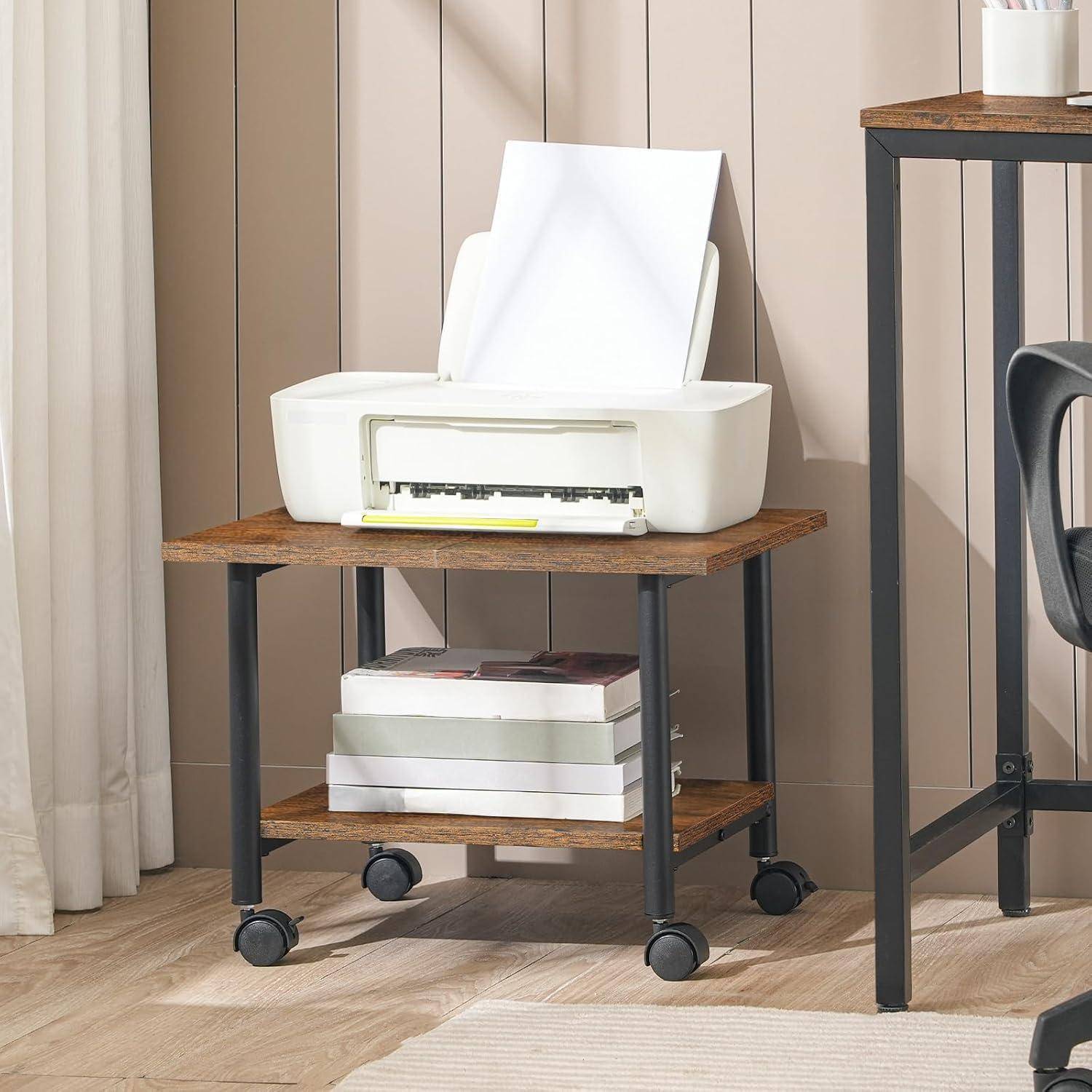 Ein modernes Homeoffice-Setting mit einem fahrbaren Holztisch, auf dem ein Drucker und ein Bücherstapel stehen, neben einem hohen Metallschreibtisch.