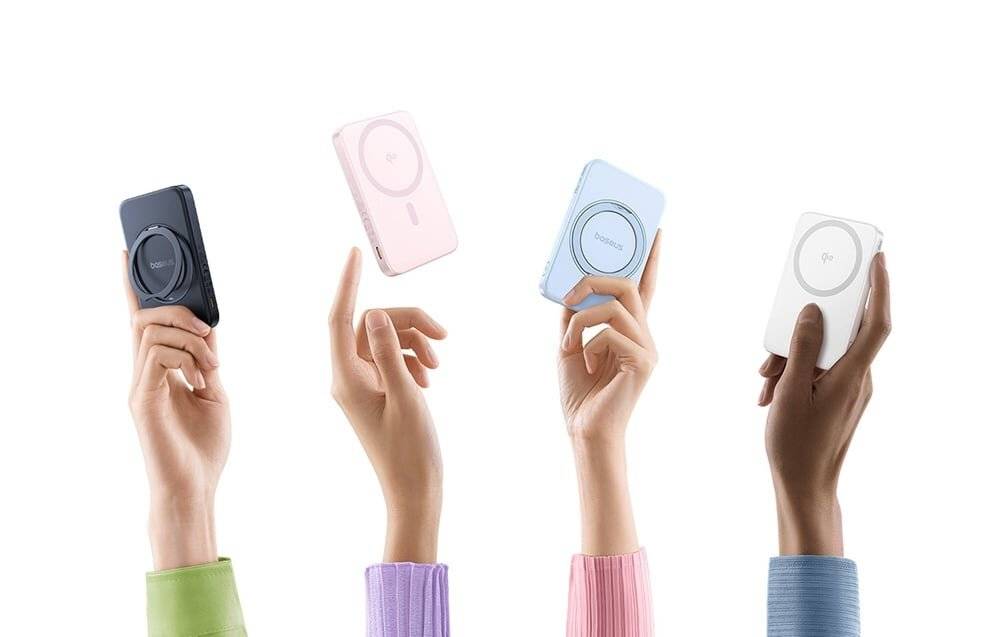 Vier Hände halten tragbare Ladegeräte in verschiedenen Pastellfarben: schwarz, rosa, blau und weiß.