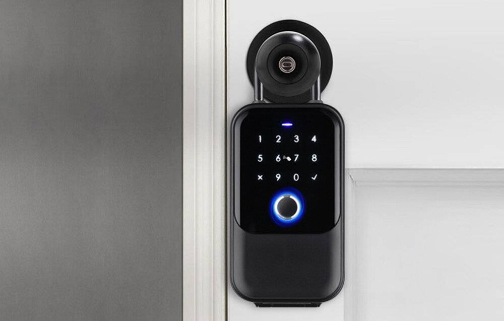 Ein intelligentes Türschloss mit einem Touchscreen-Tastenfeld, das die Zahlen 1-9 und ein Häkchen anzeigt, mit einem blau beleuchteten Kreisknopf am unteren Ende.