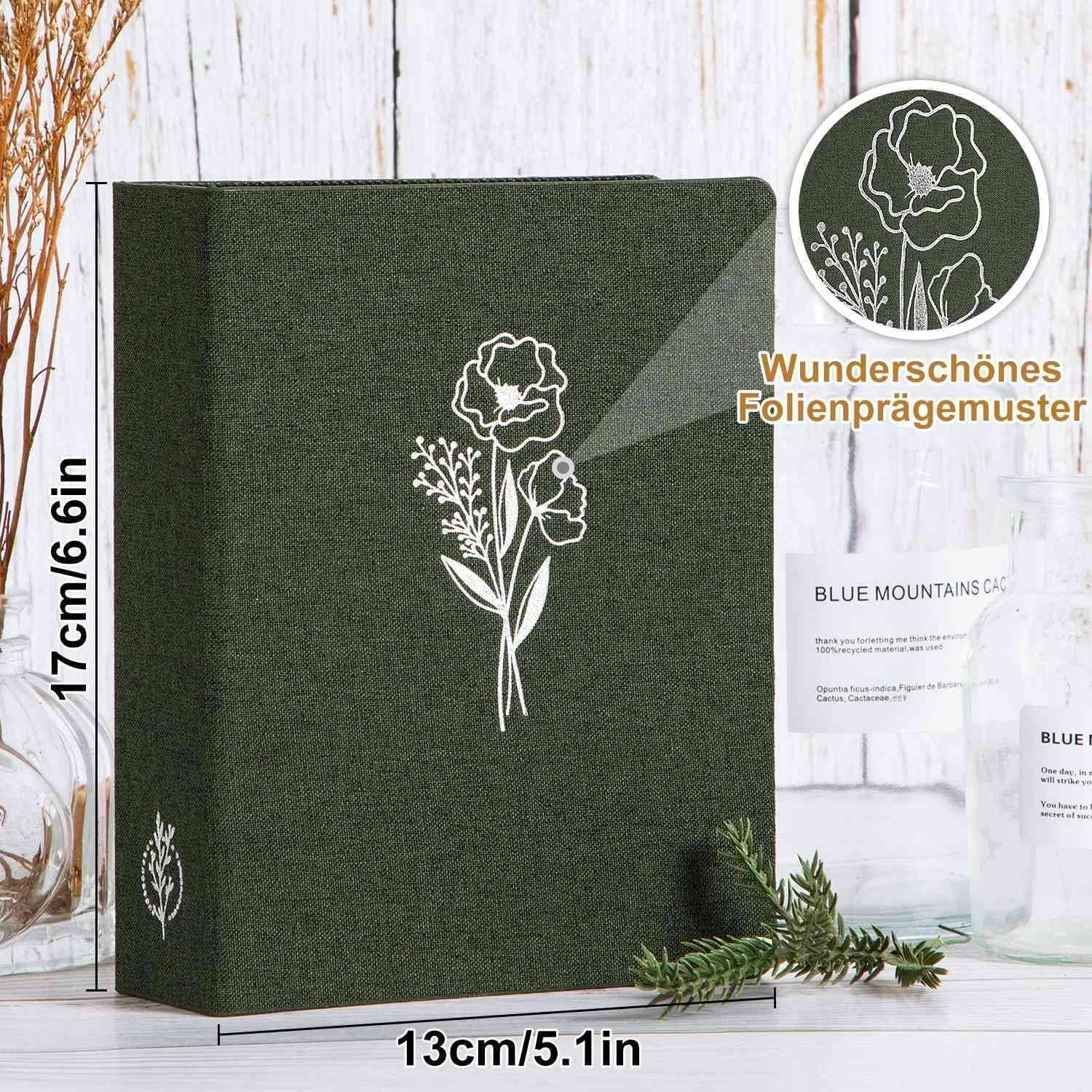 Ein grünes Buch mit einer floralen Folienprägung auf dem Einband. Die Abmessungen betragen 17 cm mal 13 cm. Die Einsatzabbildung zeigt eine Nahaufnahme der Prägung.