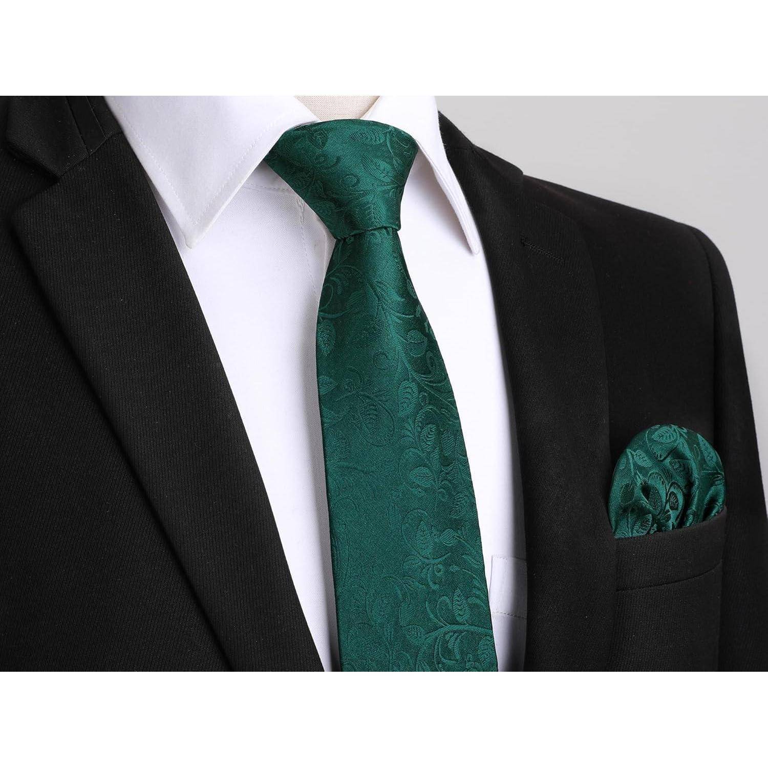 Eine Person, die einen schwarzen Anzug und ein weißes Hemd trägt, zusammen mit einer grünen Krawatte mit Paisley-Muster und einem passenden Einstecktuch.