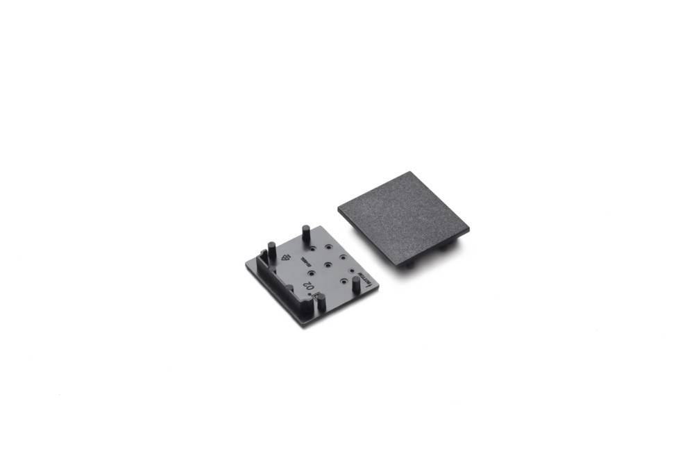 Zwei schwarze Montageplatten werden auf weißem Hintergrund angezeigt, eine mit Stiften und Löchern und die andere mit einer ebenen, flachen Oberfläche.