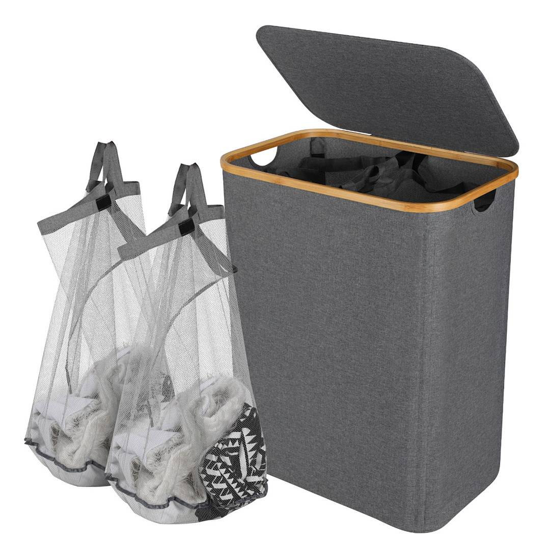 Ein grauer Wäschekorb mit offenem Deckel neben zwei Netz-Wäschesäcken, die Kleidung enthalten.