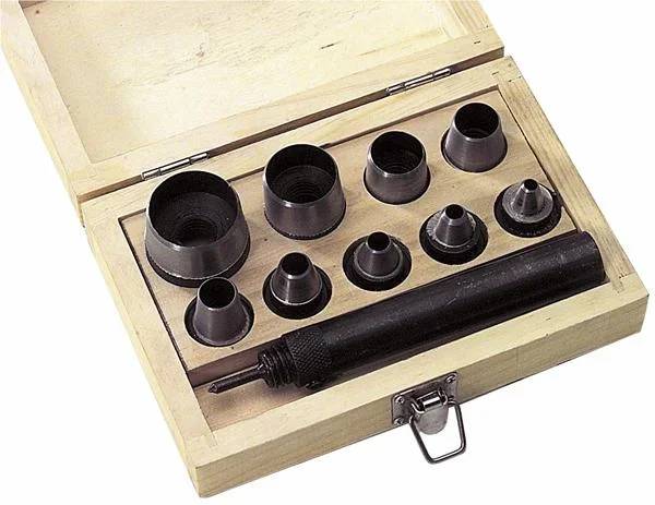 Holzkasten mit einem Satz verschiedener Metallstanzwerkzeuge in unterschiedlichen Größen zum Lochen oder Stanzen von Löchern in Materialien.