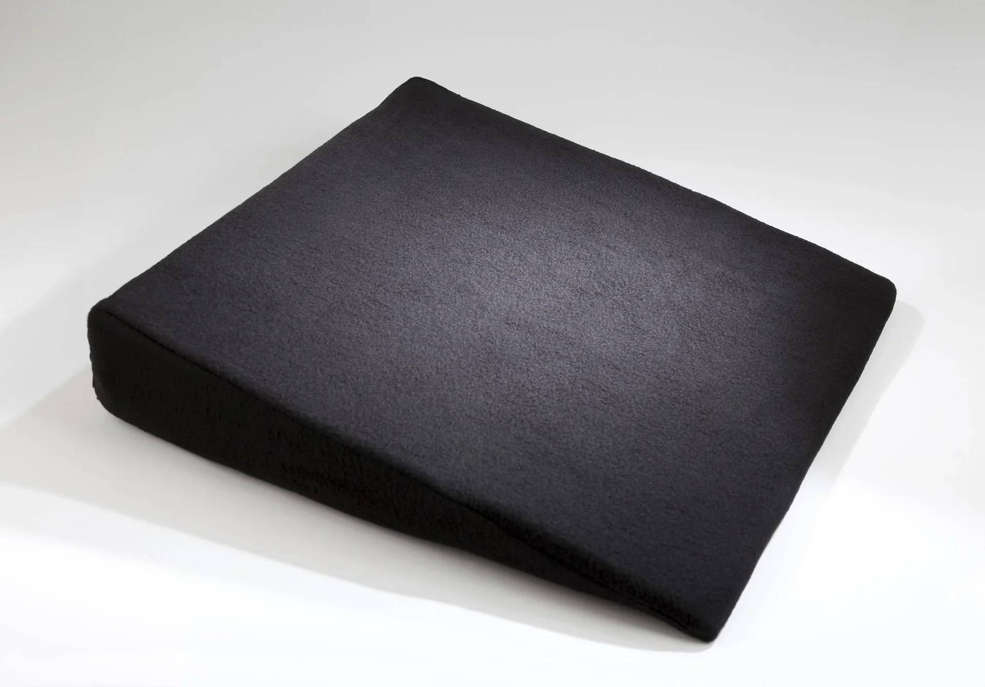 Ein dunkelgraues Sitzkissen aus Memory Foam mit leichter Neigung, das entwickelt wurde, um Komfort und Unterstützung zu bieten.