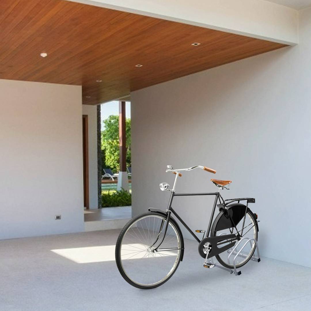 Ein Fahrrad im Vintage-Stil mit schwarzem Rahmen und braunem Sattel steht in einem modernen, offenen Flur mit Holzdecke, der den Blick auf einen Garten eröffnet.