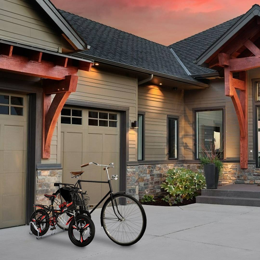 Ein modernes Haus mit Steinfassade und Holzakzenten bei Sonnenuntergang, mit einer Garage und Fahrrädern, die draußen auf der Auffahrt geparkt sind.
