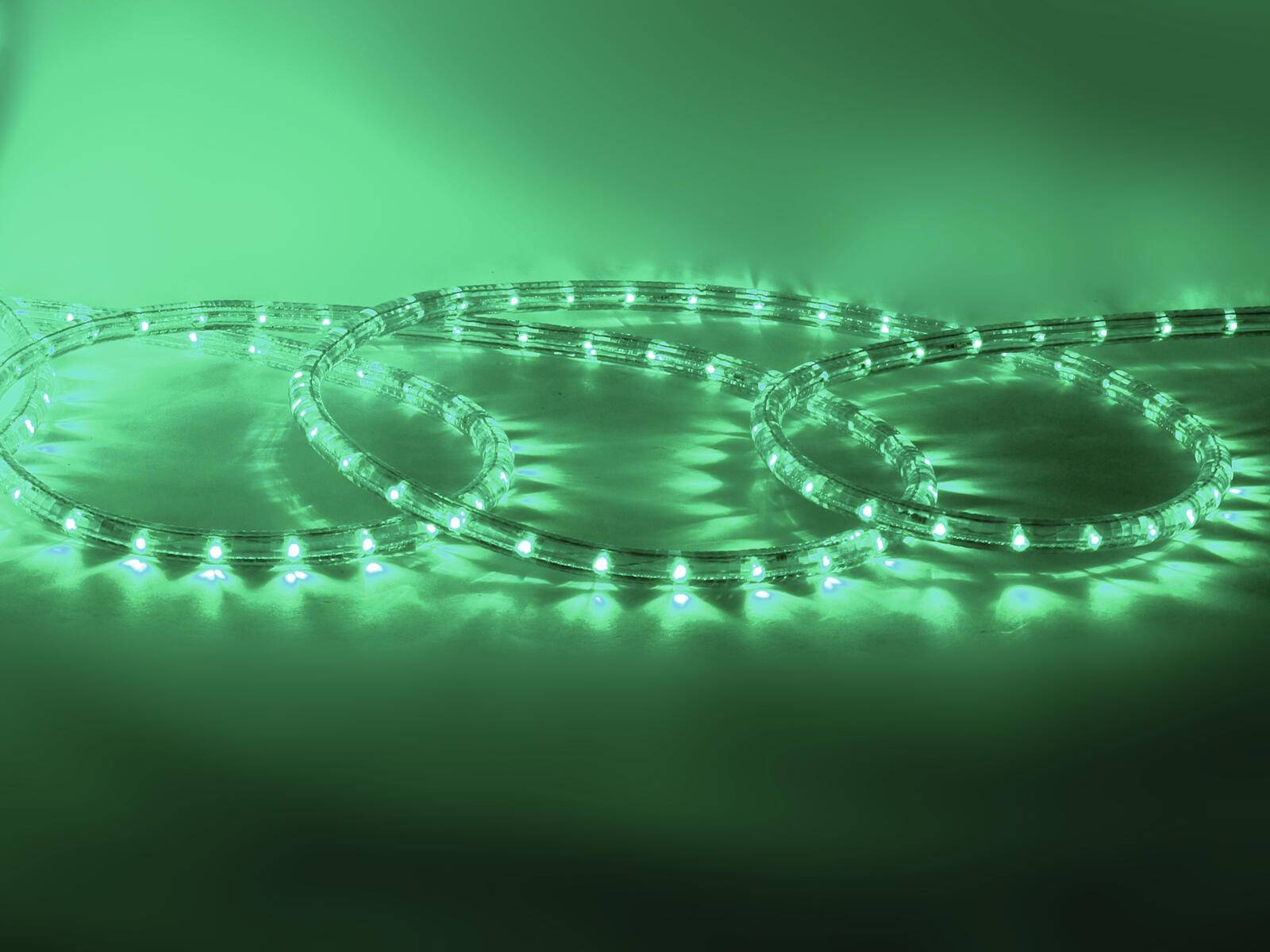 Grüne LED-Lichtstreifen in überlappenden kreisförmigen Mustern auf einer reflektierenden Oberfläche angeordnet, die ein leuchtendes Glühen erzeugen.