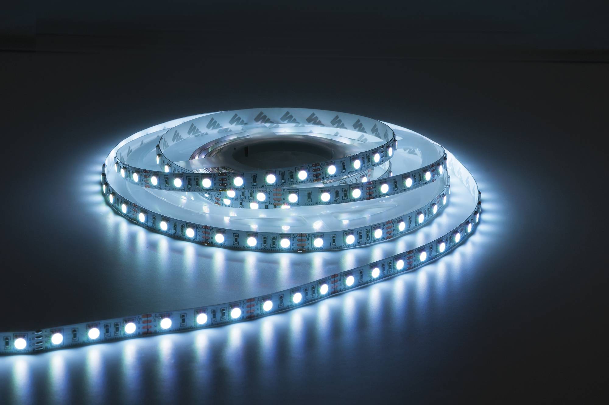 Ein aufgerollter Streifen von LED-Leuchten, die hell gegen einen dunklen Hintergrund leuchten und ihre Flexibilität und Helligkeit zeigen.