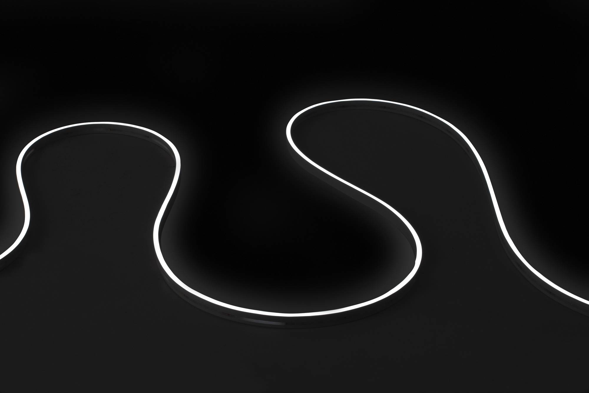 Ein leuchtender, gekrümmter Lichtstreifen auf dunklem Hintergrund, der eine U-Form bildet. Das Licht strahlt einen sanften, weißen Glanz aus und erzeugt eine moderne, minimalistische Ästhetik.