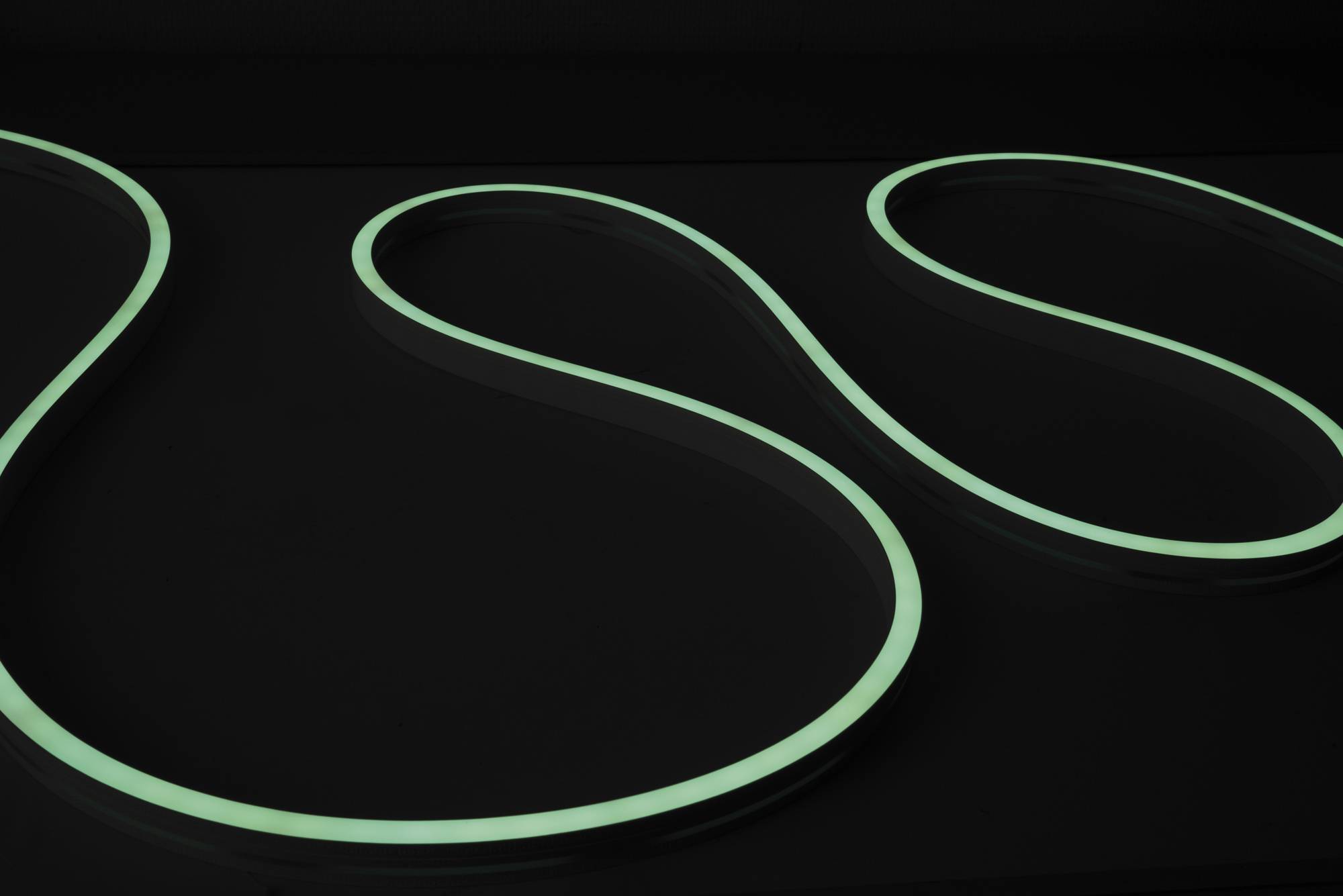 Eine leuchtende, wellenförmige Linie auf dunklem Hintergrund, die einem stilisierten „S