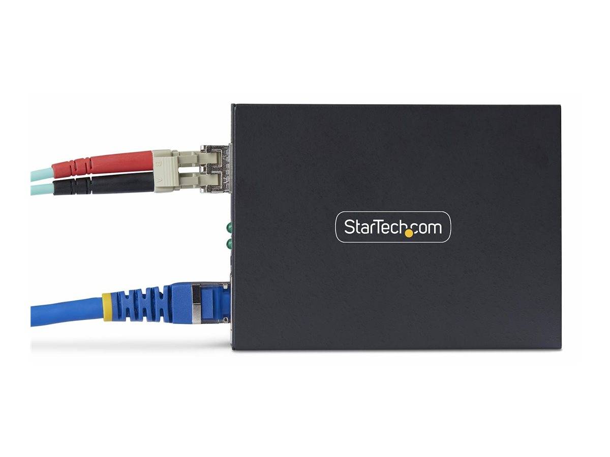 StarTech.com Netzwerkgerät in Schwarz mit zwei verbundenen Ethernet-Kabeln, gezeigt in Profilansicht auf weißem Hintergrund.