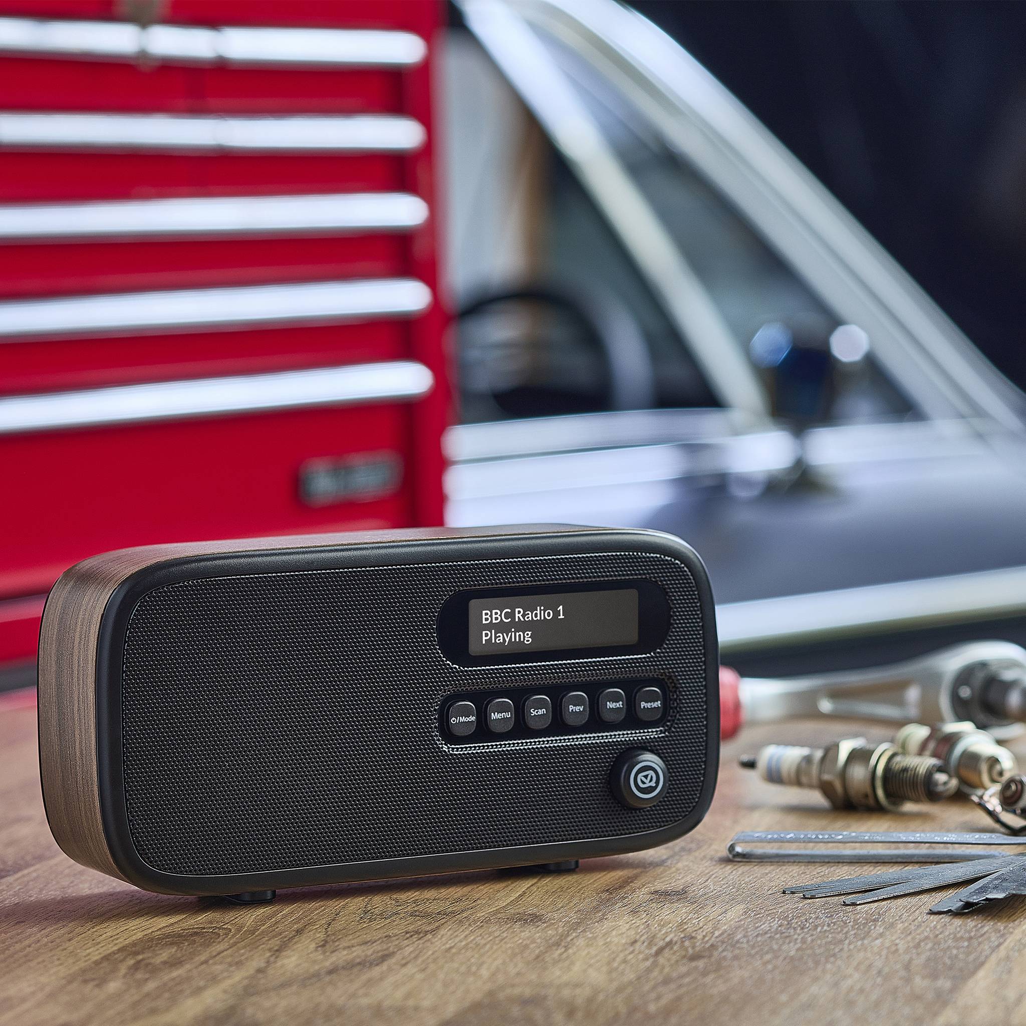 Ein Vintage-Radio mit digitalem Display steht auf einem Holztisch und zeigt 