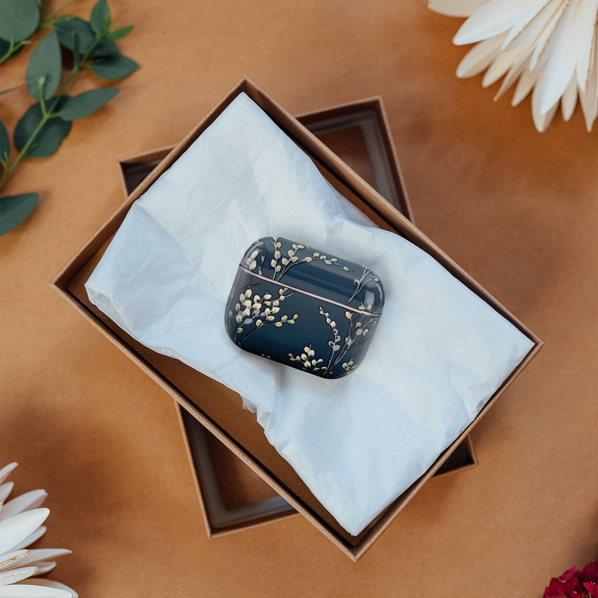 Dekorativer Kasten mit Blumenmuster in einer Geschenkbox, umgeben von Blumen.