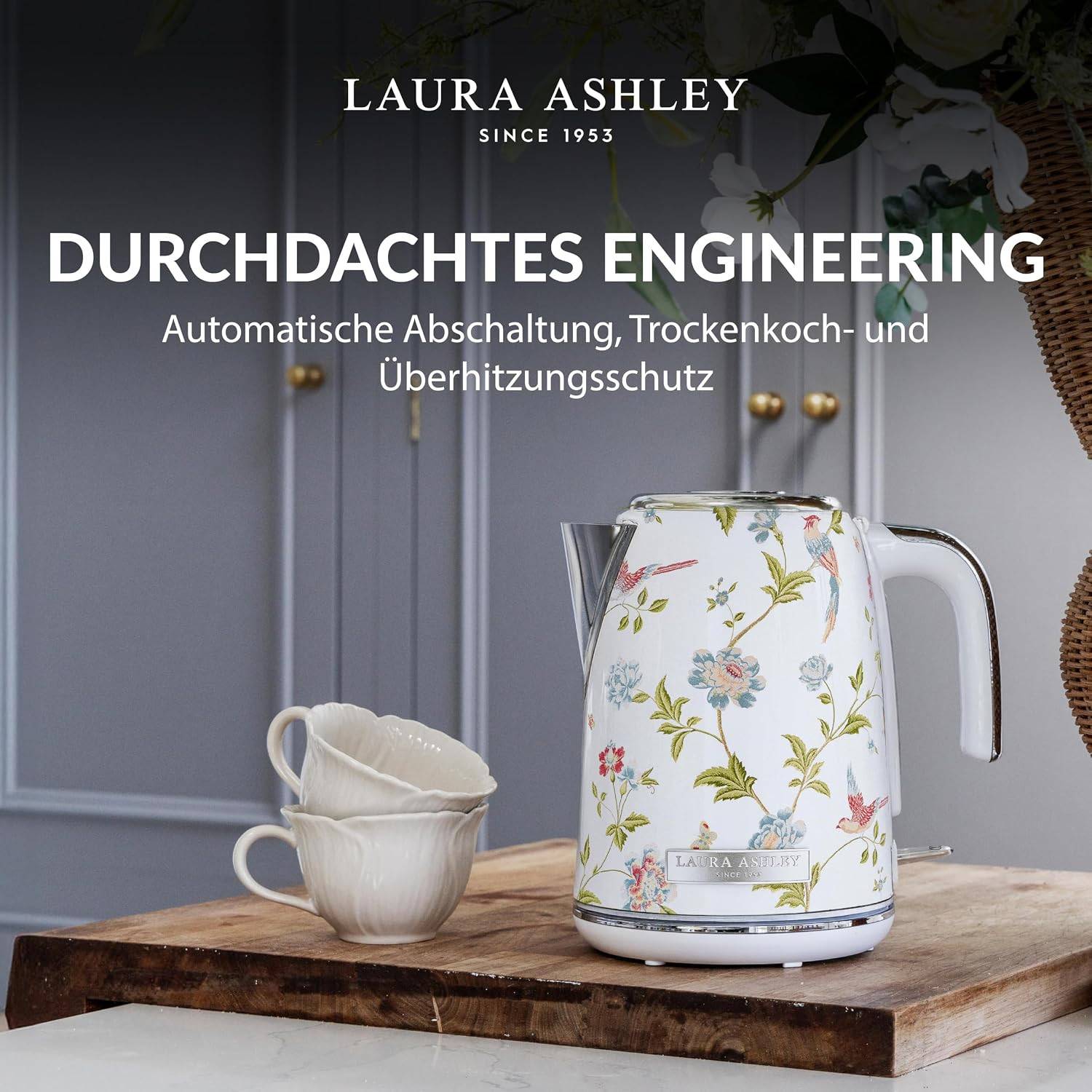 Laura Ashley florales elektrisches Wasserkocher auf einem Holzbrett mit zwei Tassen; Text sagt „DURCHDACHTES ENGINEERING" und „Automatische Abschaltung, Trockenkoch- und Überhitzungsschutz"".