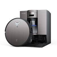 Ein Roboterstaubsauger und seine Ladestation werden gezeigt. Der Staubsauger hat eine metallische Oberfläche, und die Station dient wahrscheinlich als Ladegerät.