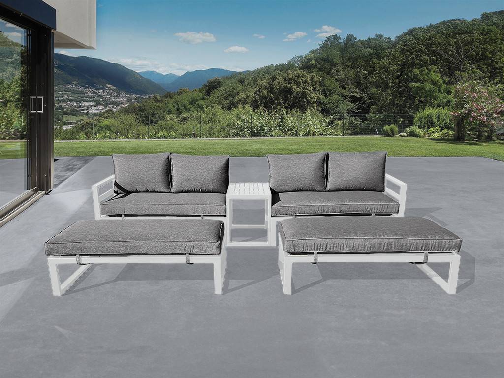 Modernes graues Outdoor-Ecksofa mit weißen Rahmen und Ottomane auf einer Terrasse mit Blick auf einen Rasen und eine Berglandschaft.