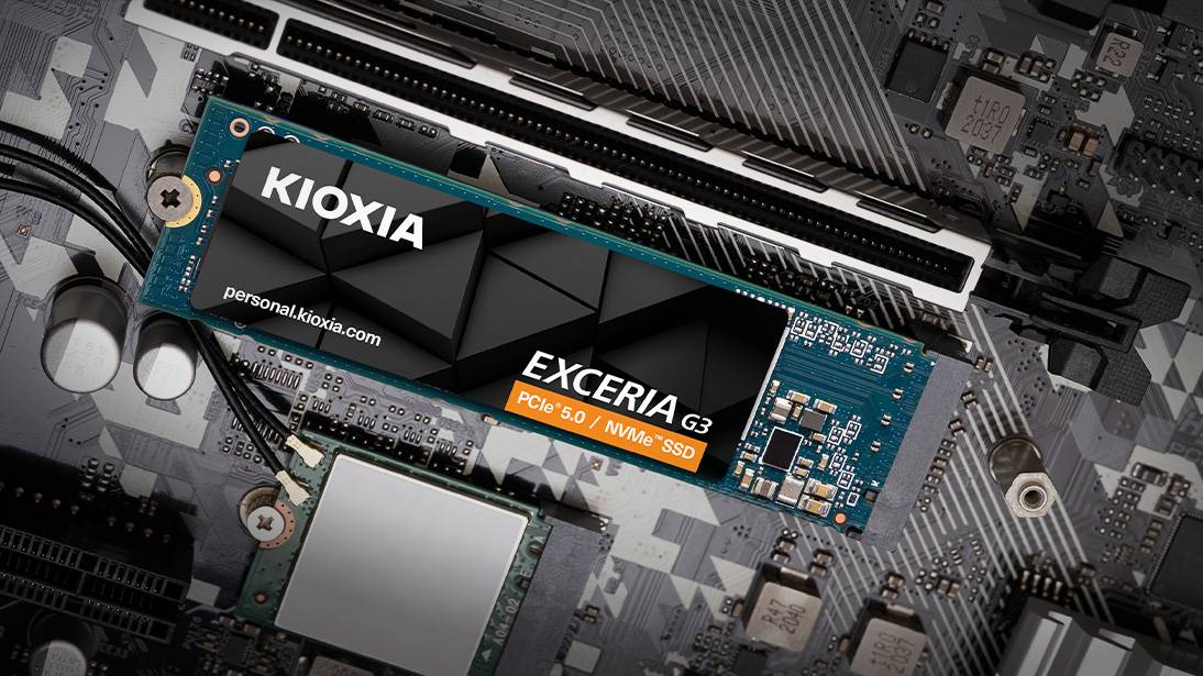 Ein Kioxia Exceria G3 NVMe SSD, das auf einem Computer-Motherboard installiert ist, wobei seine blaue Leiterplatte und das schwarze Label mit Spezifikationsdetails hervorgehoben werden.