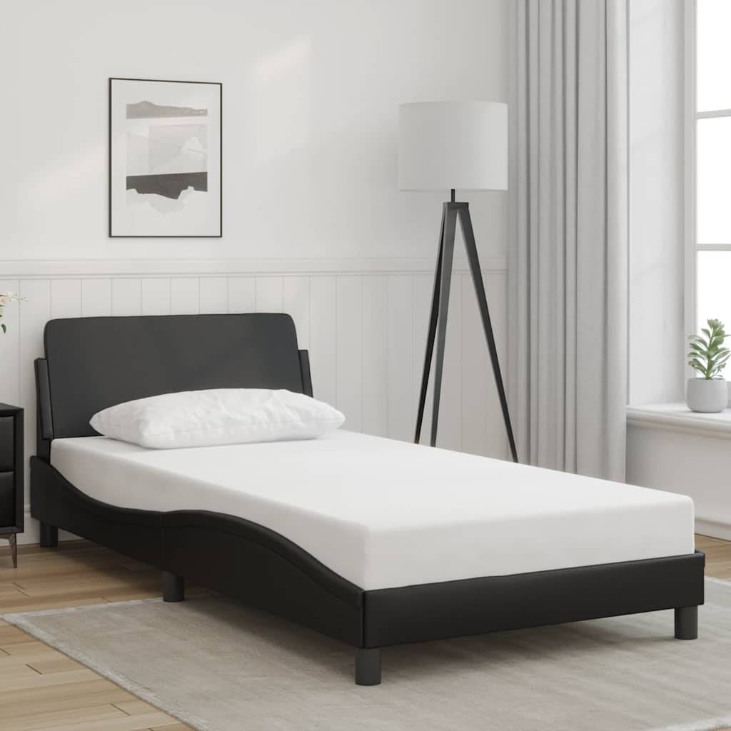 Ein minimalistisches Schlafzimmer mit einem eleganten schwarzen Bett, weißer Bettwäsche, einer Lampe, gerahmten Wandbildern und einer Pflanze am Fenster, die eine ruhige Atmosphäre schafft.