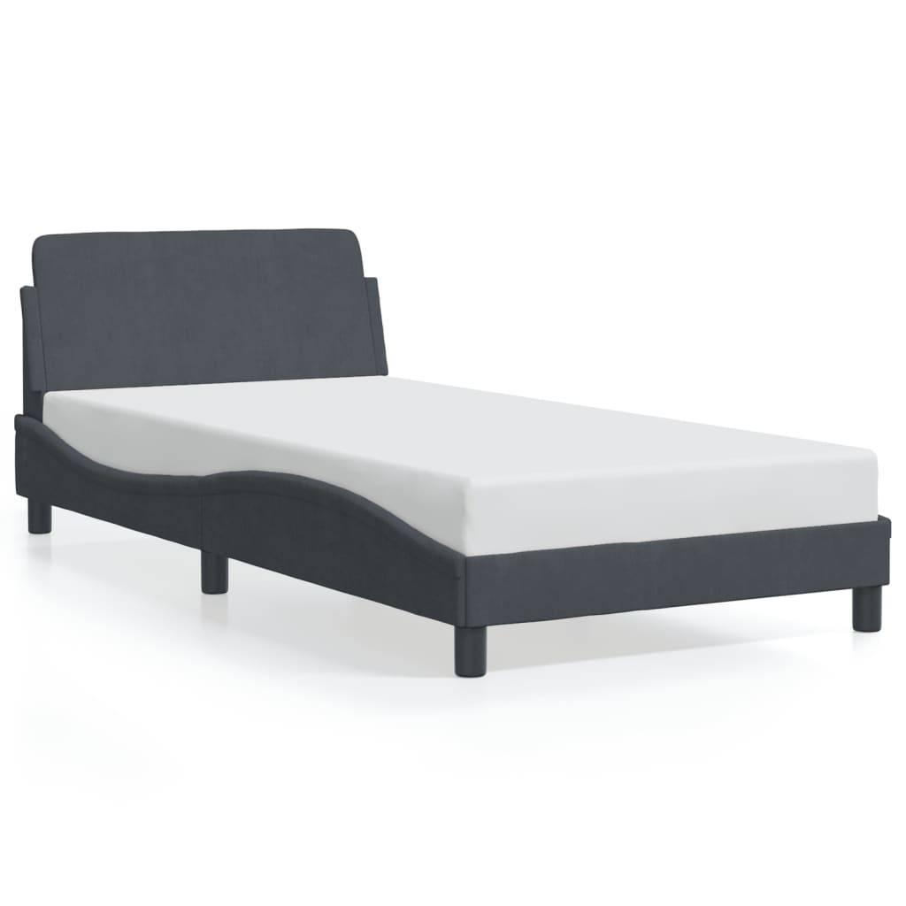 Ein modernes Einzelbett mit dunklem gepolstertem Rahmen und weißer Matratze, auf einer glänzenden Oberfläche platziert, das ein schlankes Design hervorhebt.
