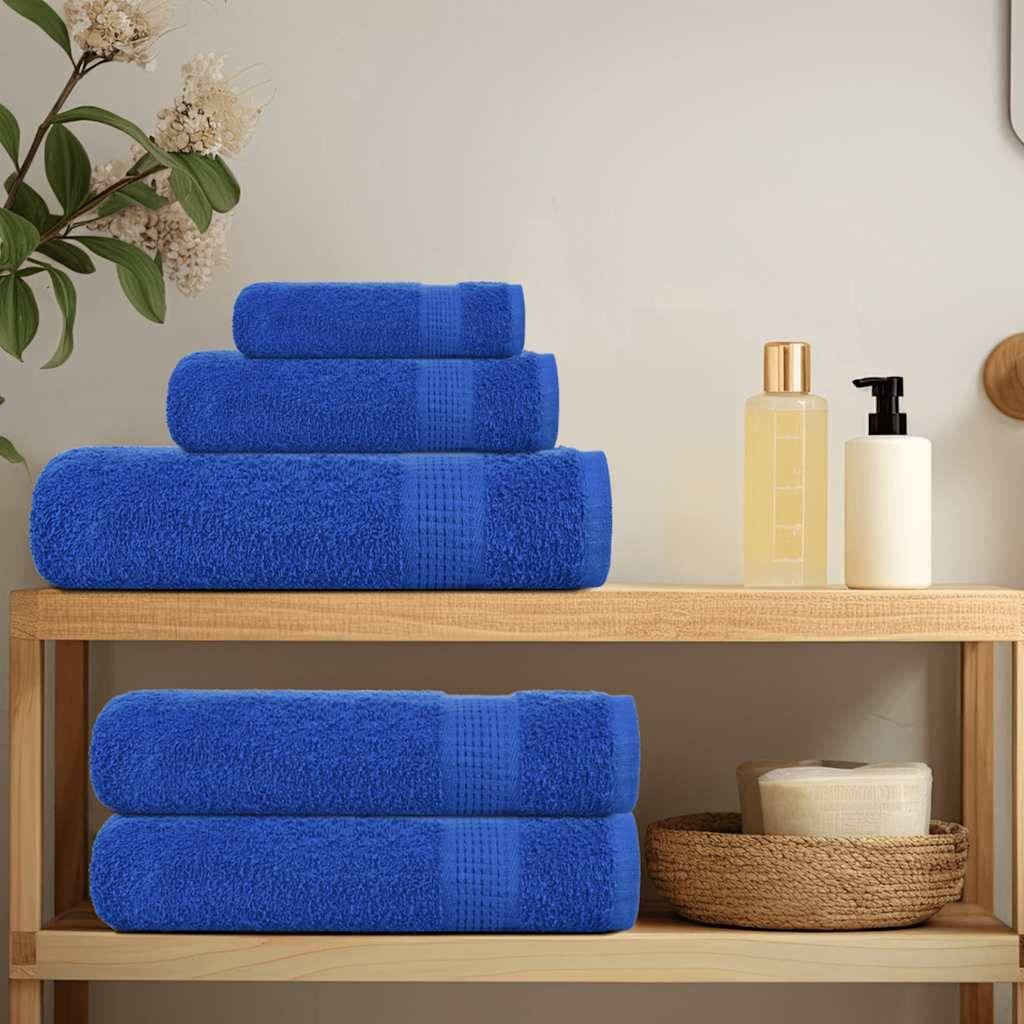 Blaue Handtücher ordentlich gestapelt auf einem Holzregal neben Toilettenartikeln und einer Zimmerpflanze, die eine aufgeräumte und einladende Badezimmereinrichtung schaffen.